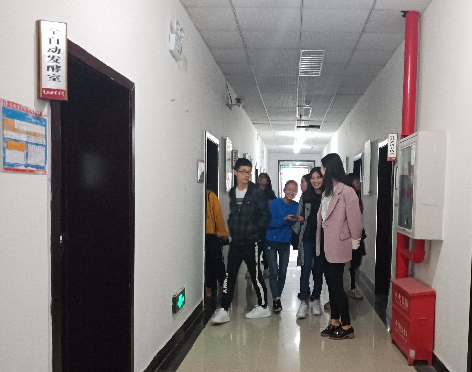 图一 食品院工作人员带领大家参观实验室.jpg